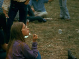 Jackie Barg Sitting on the Ground and Blowing Bubbles, During the Woodstock Music and Art Fair