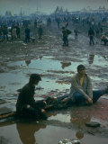 Chuck Morgan Sitting in the Mud and Water with a Friend, During Woodstock Music and Art Fair