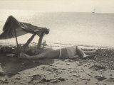 Two Women Lying on the Sea Shore in the Shade of a Towel