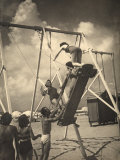 Group of Youths Having Fun on a Swing at the Beach