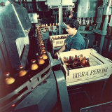 Peroni Factory, Worker Operating a Machine That Moves Bottles Full of Beer