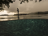 Fishermen tie their outriggers to trees overhanging a coral islet