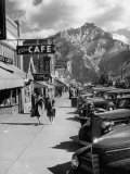 Buy Pedestrians Walking Along Main Street in Resort Town with Cascade Mountain in the Background at AllPosters.com