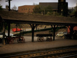 Buy Small Railway Station with Wooden Buckboards for Baggage, Period Cars in Lot at AllPosters.com