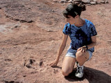 Teenage Girl Looking at Fossil Dinosaur Footprint Near Tuba City, Arizona