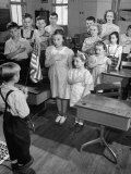 Children Reciting the Pledge of Allegiance as a Boy Holds the Us Flag in their Classroom