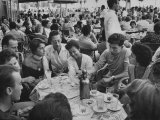 Crowded Outdoor Cafe in Rapallo, People Seated around Small Tables, Waiter Passing Through
