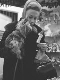 Shopper Looking at Tiny Figurine as She Holds Her Yorkshire Terrier in Arms at Saks Fifth Avenue