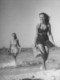 Buy Smiling Girls Carrying Skis Out of the Water onto Beach at AllPosters.com