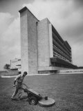 Buy Man Mowing Grass Near New Hospital at AllPosters.com