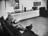 Buy Architect Mies Van Der Rohe Relaxing on Couch While Smoking Cigar and Reading at Home at AllPosters.com