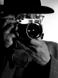 Photographer Henri Cartier-Bresson Wearing Hat and Holding Camera Up to His Face