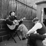Folk Singer Woody Guthrie Palying His Guitar While Getting a Shoeshine
