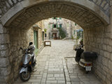 Scooters under stone bridge, Stari Grad Town, Hvar Island, Dalmatia, Croatia
