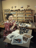 Woman Paints Clay Busts of Dogs Using Magazine Illustrations as Guide