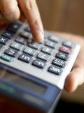 Close-up View of Female Hands Using a Calculator