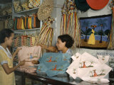 Buy Shopkeeper at an Arts Co-Op Shows a Customer Embroidered Linens at AllPosters.com