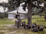 Schoolboys Sit in the Shade of a Tree Outside a Rural Schoolhouse