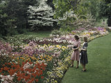 Buy Two Women Admire Tulips in a Garden at AllPosters.com