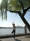 Young Chinese Woman Doing Yoga and Meditation Beside a Lake in the Morning