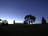 Star Above a Barn and Trees Backlit by Breaking Dawn