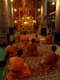 Buddhist Monks in a Temple Seated before a Gilded Buddha Statue