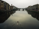 Lone Rower Plys the Calm Waters of a Canal in Florence, Italy
