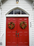 Vintage Red Church Doors with Wreaths Offer a Bright Welcome
