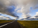 Truck on a Road under a Sky Filled with Heavy Clouds