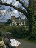 Young Woman with a Backpack Strides Down a Country Lane Photographic Print