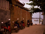 Motorcycles Along a Wall at the Waterfront at Sunset on Koh Lanta - Party Travel