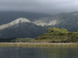 Sunlight Piercing Storm Clouds Illuminates a Rugged Granite Crag