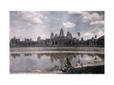 Buy Person Sits by a Moat Which Surrounds the Towers of Angkor Vat at AllPosters.com