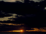 Setting Sun Pierces a Menacing Storm Front over the Atlantic