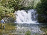 Buy Man in Boots Casts a Line by a Waterfall as He Fishes for Trout at AllPosters.com