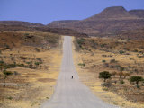 Single Figure Walking Down a Long Road in Namibia