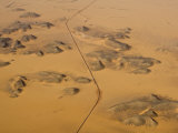Aerial View of a Road Slicing Through a Desert with Sand Dunes