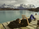 Buy Woman Relaxes on a Dock While Reading a Book at AllPosters.com