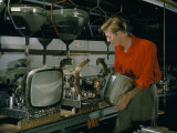 Man Adds a Television Picture Tube to a Chassis on an Assembly Line