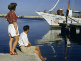 Buy Couple Looks at a Marshall Plan Showboat in Rhodes Harbor at AllPosters.com