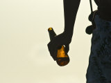 Man Holds an Almost Empty Bottle of Beer on a Hot Summer Afternoon