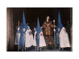 Penitents March in a Malaga Street Procession During Holy Week
