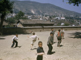 Buy Boys Play Soccer in Sandy Yard Overlooking Rooftops at AllPosters.com