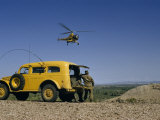 Buy Serviceman Watching Hovering Helicopter Stands Beside a Yellow Truck at AllPosters.com