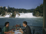 Couple Dines on a Restaurant Balcony Overlooking a Waterfall Photographic Print