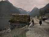 Two People Stand on a Dirt Road Along a Fjord Leading to Mundal