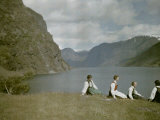 Norwegian Women in Traditional Dress Relaxing in a Scenic Fjordland