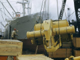 Buy Longshoreman Directs Loading of Road-Building Machine onto Cargo Ship at AllPosters.com