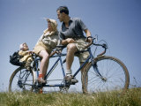 Man and Woman Straddling Tandem Bicycle Look at Child in Back Seat