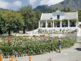 Buy Woman Admires Flower Garden in Front of Dutch Colonial-Style Home at AllPosters.com